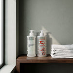 Magnesium and Tai massage oils 500 ml on a shelf with folded towels